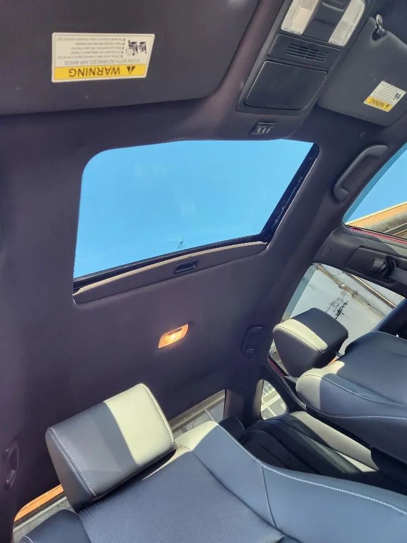 Car interior with a large sunroof and blue sky visible overhead