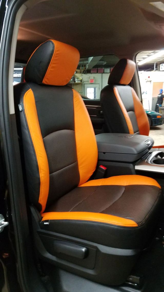 Two orange-and-black car seats in a vehicle interior