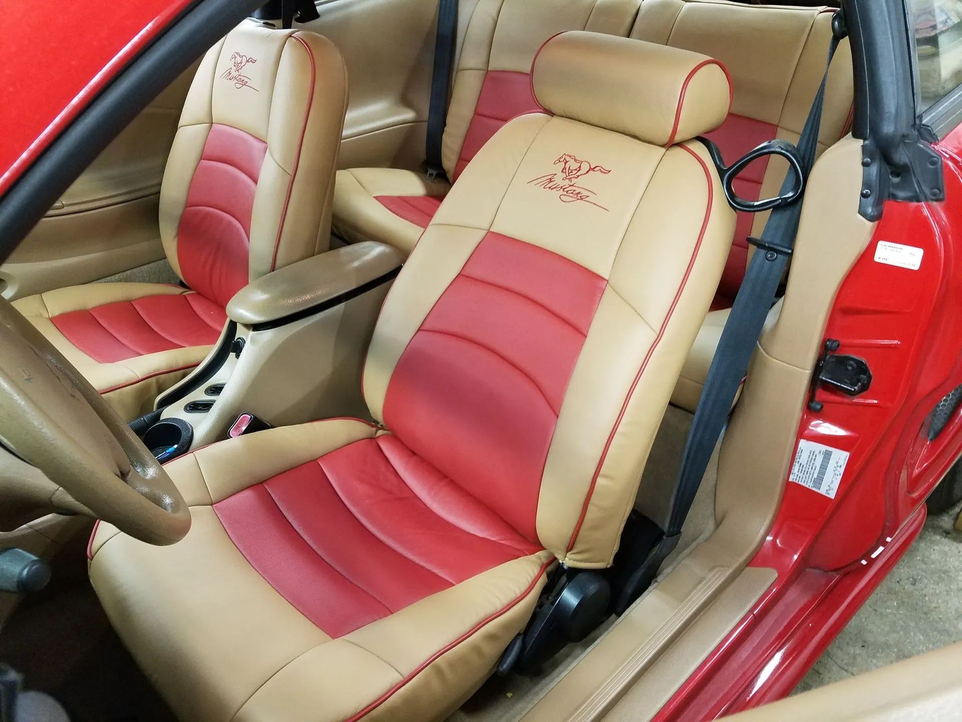 Two-tone tan and red car seats inside a red convertible interior