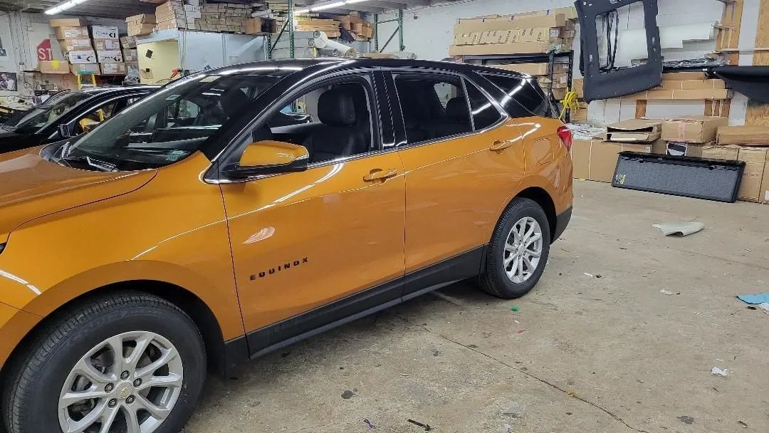 Orange SUV parked inside an auto shop garage