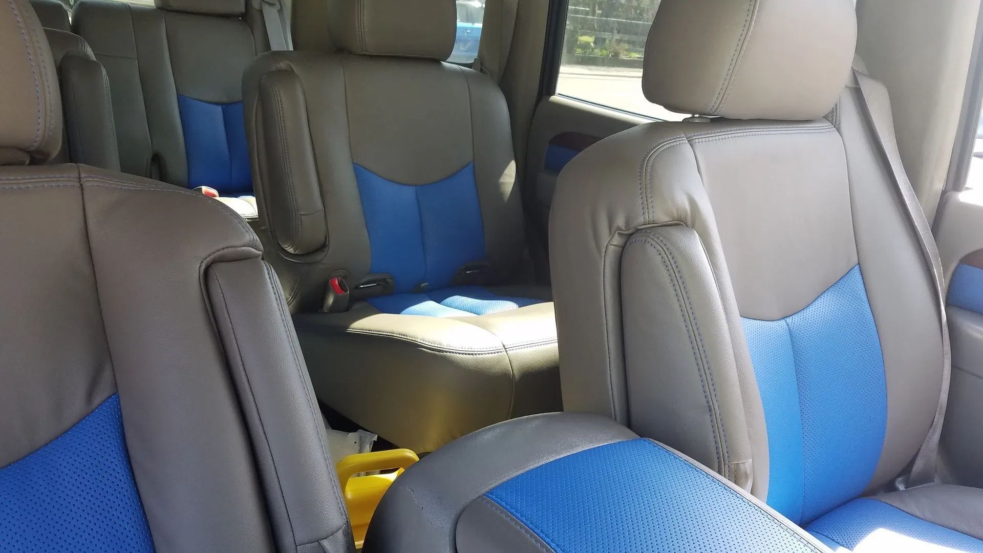 Blue-and-gray car interior with seats and headrests visible, viewed from the back seat area