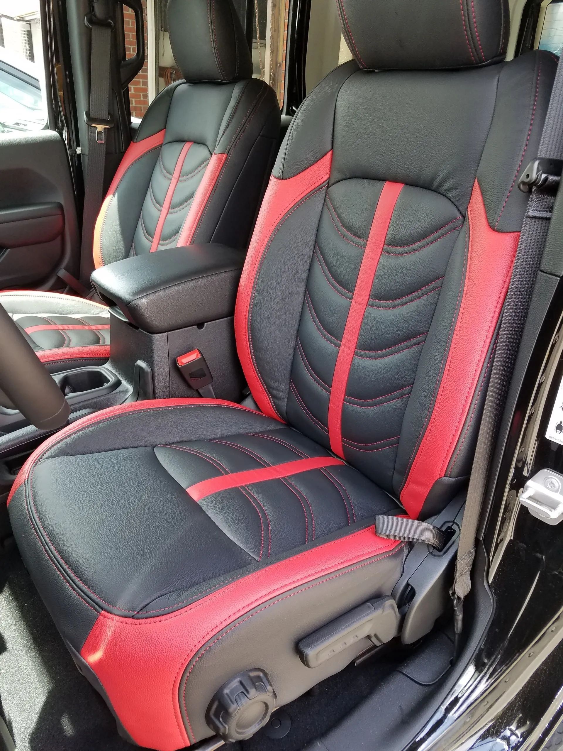 Black and red car seat covers on front seats inside a vehicle