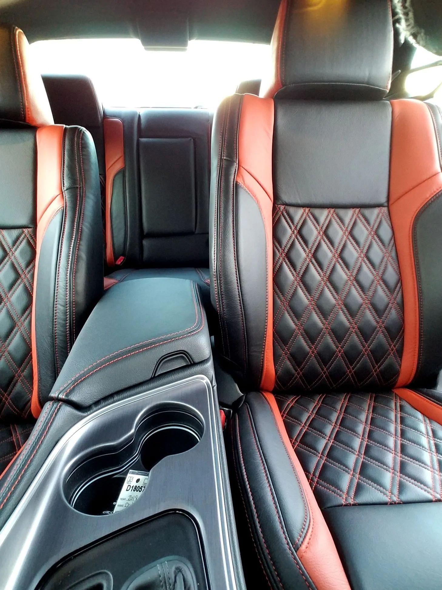 Car interior with black and red quilted seats and a center console with cup holders