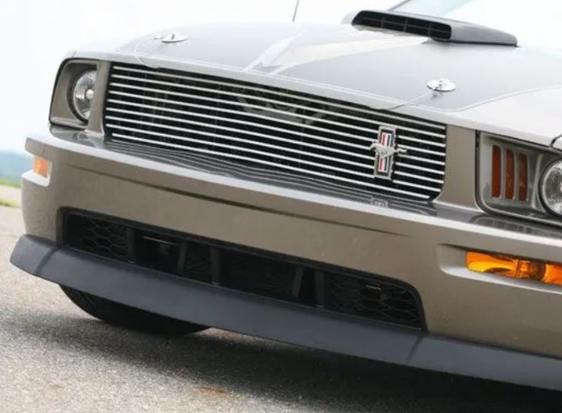 Front view of a silver classic car with chrome grille and black bumper trim