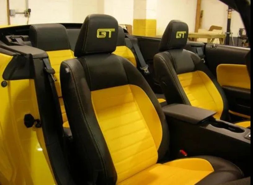 Yellow-and-black GT sports car seats inside a vehicle interior