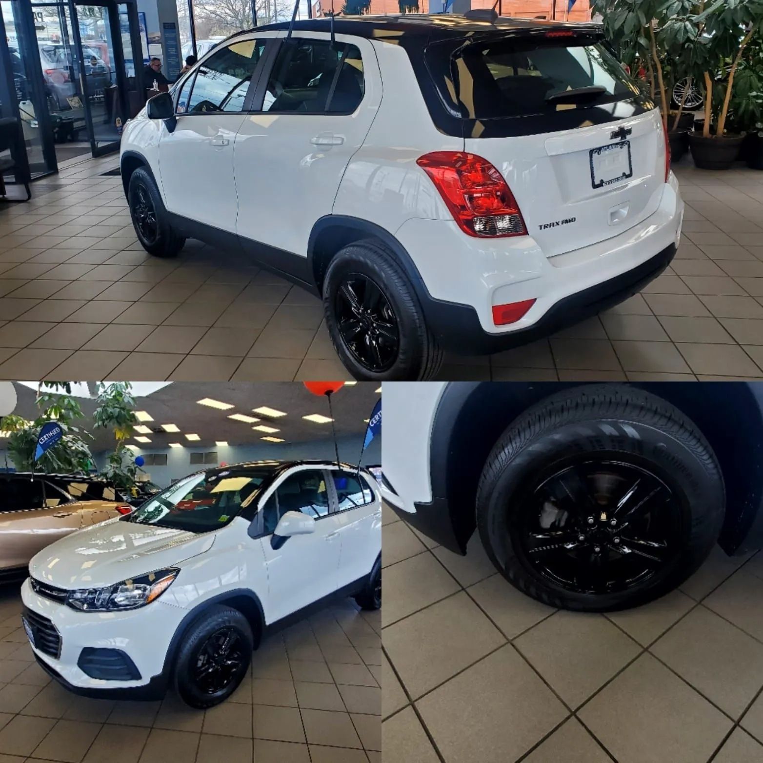 White compact SUV with black wheels, shown from rear and front angles in a showroom.