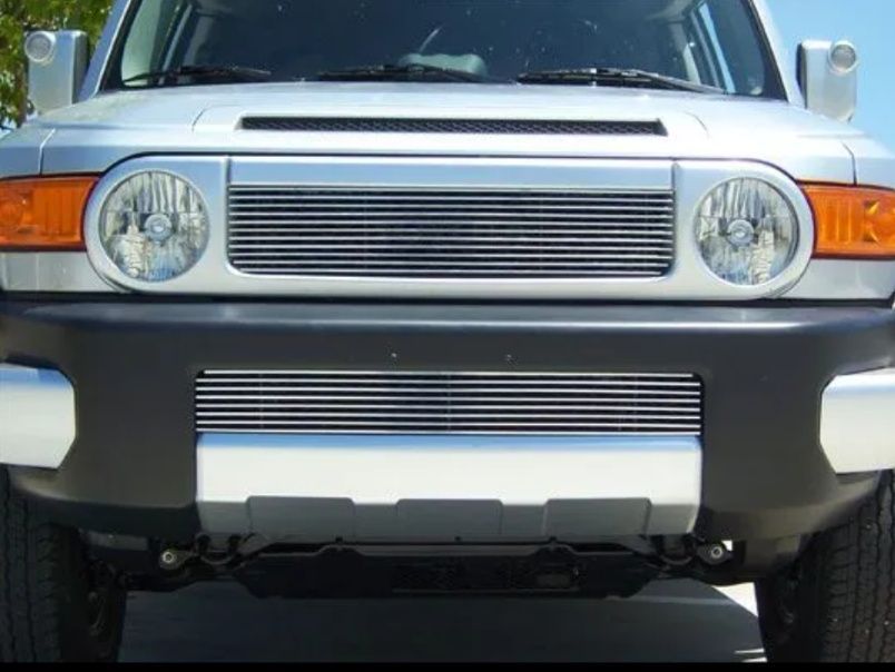 Front view of a silver off-road SUV with round headlights and orange turn signals