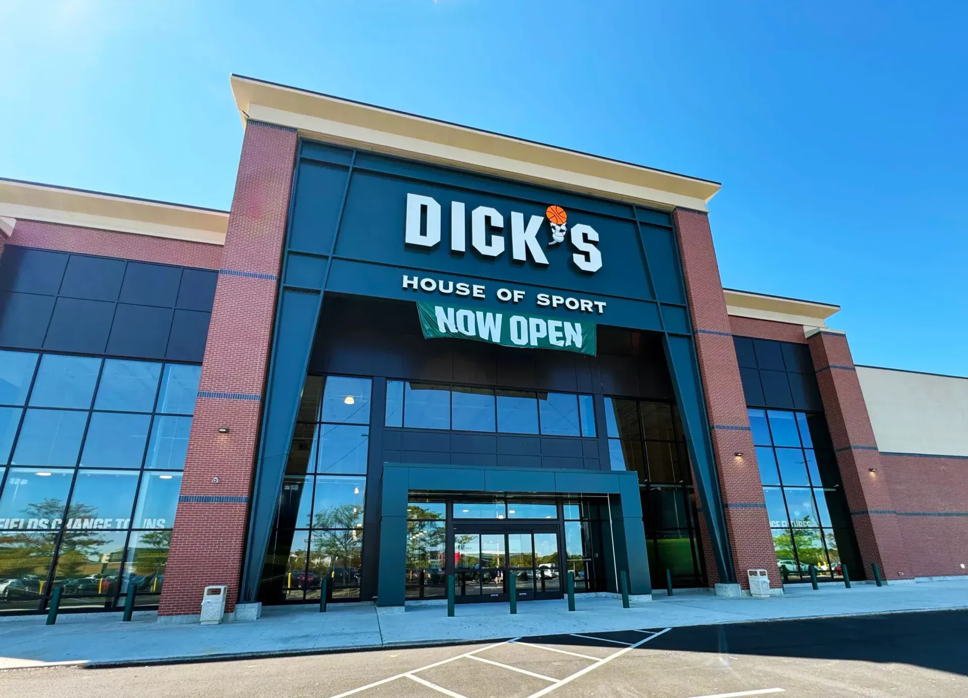 Dick’s House of Sport storefront with large sign and glass entrance under a blue sky