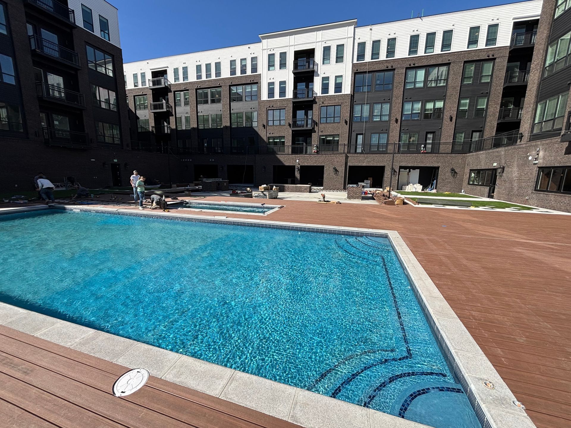 Courtyard swimming pool with turquoise water beside a modern apartment building