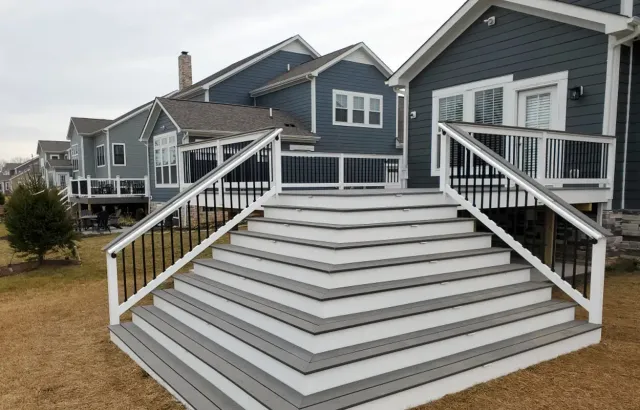 Modern gray townhouse exterior with wide front steps and white railings