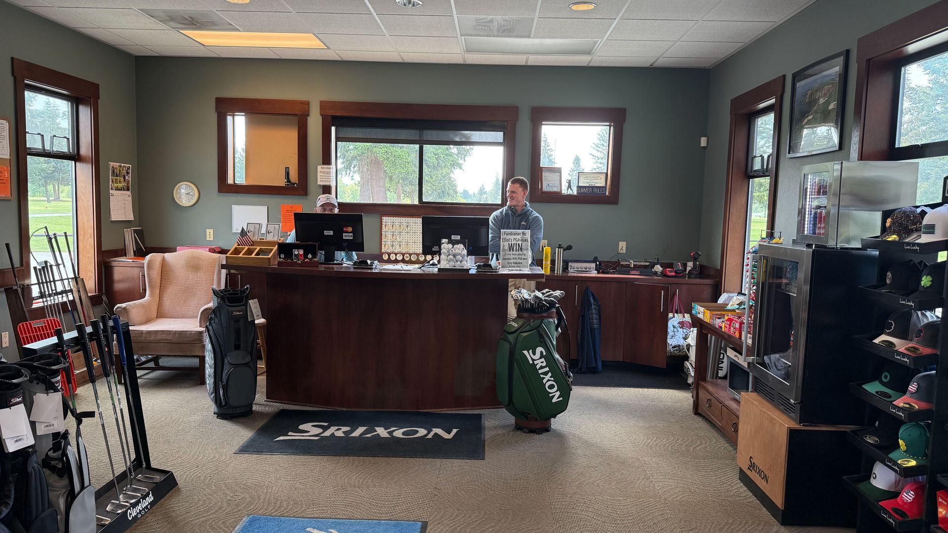 A man is standing behind a counter in a golf store