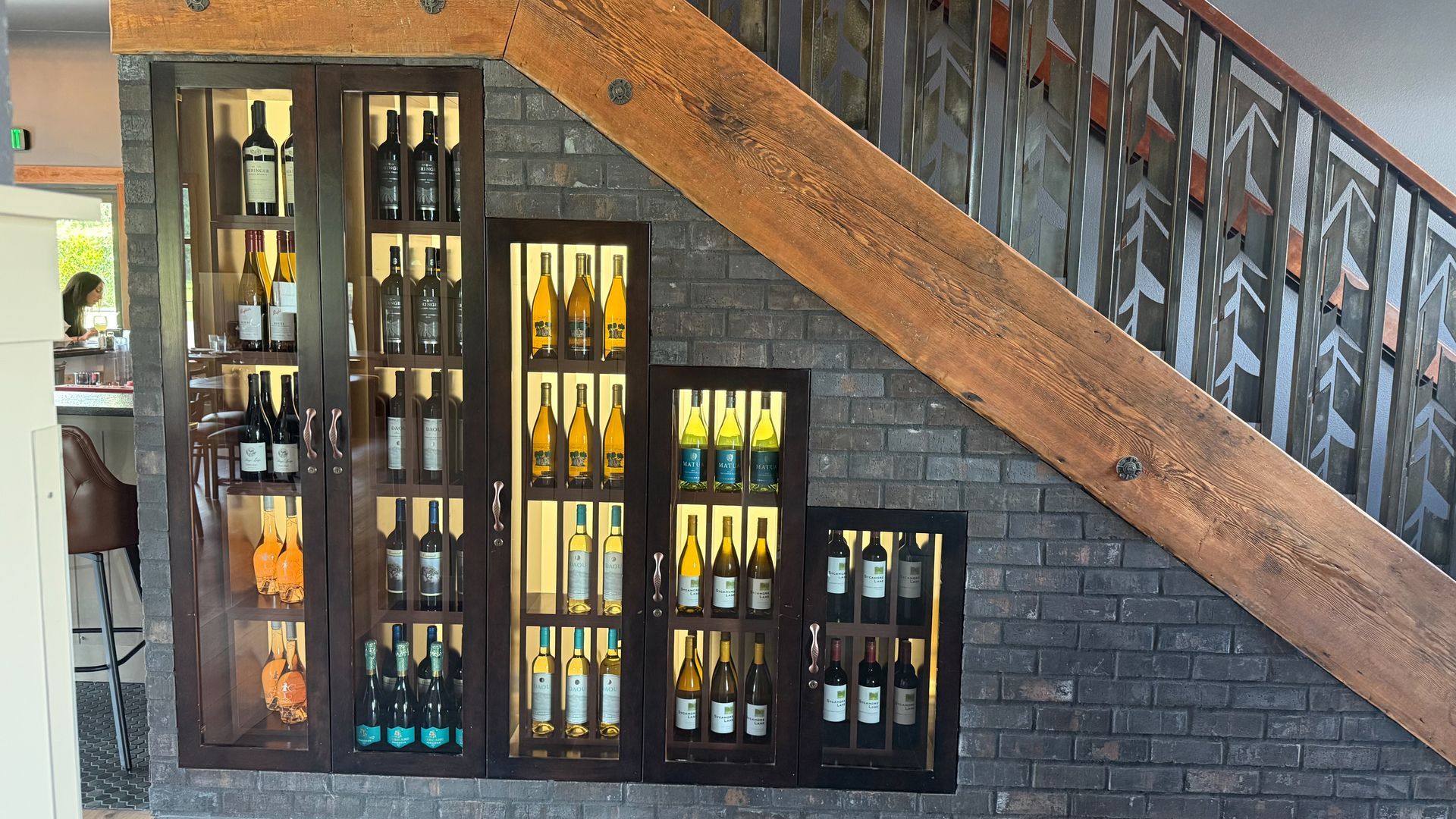A staircase with a display of wine bottles on the wall