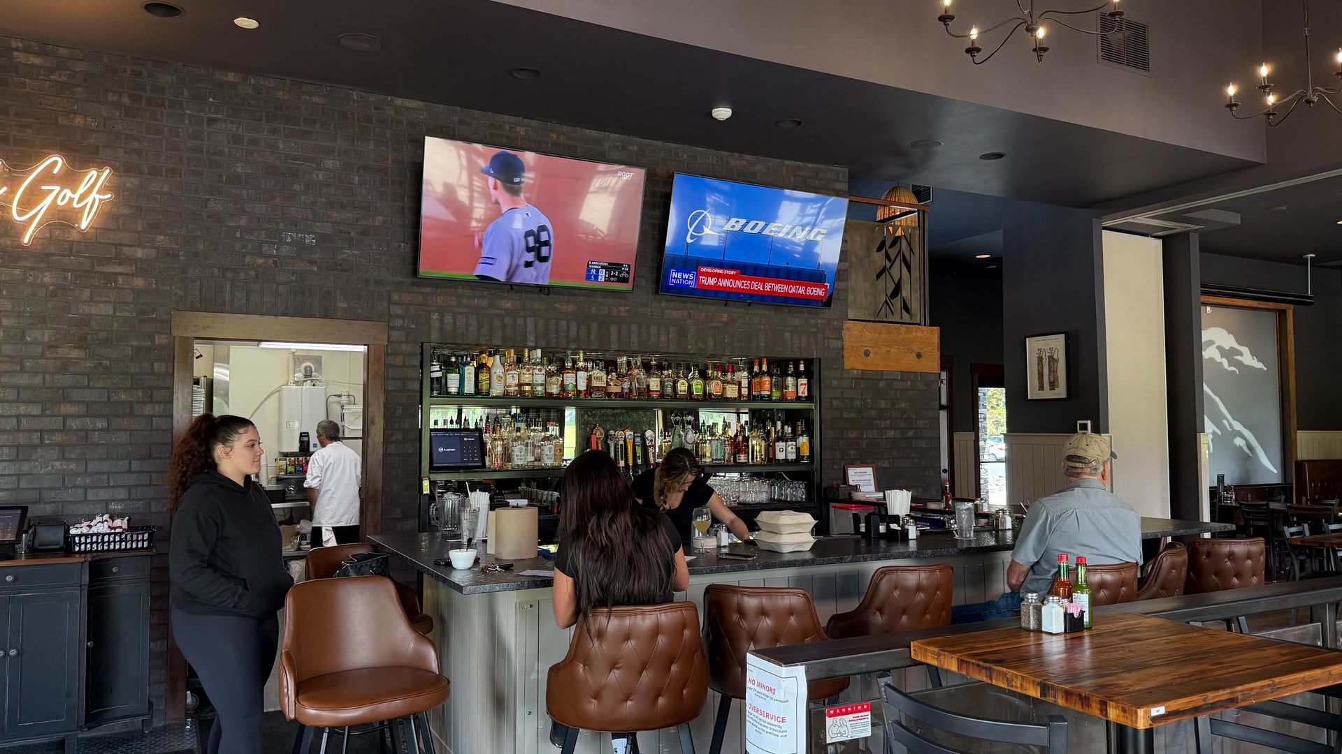 A group of people are sitting at a bar in a restaurant