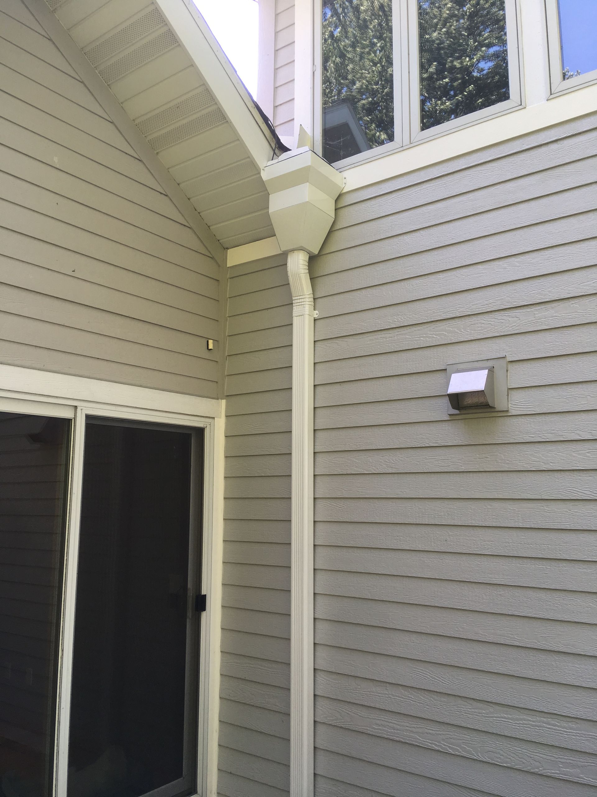 A house with a gutter on the side of it and a window.