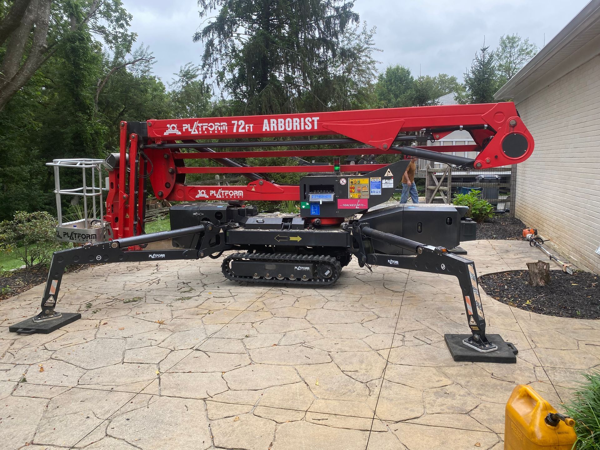 A red spider lift is parked in front of a house.