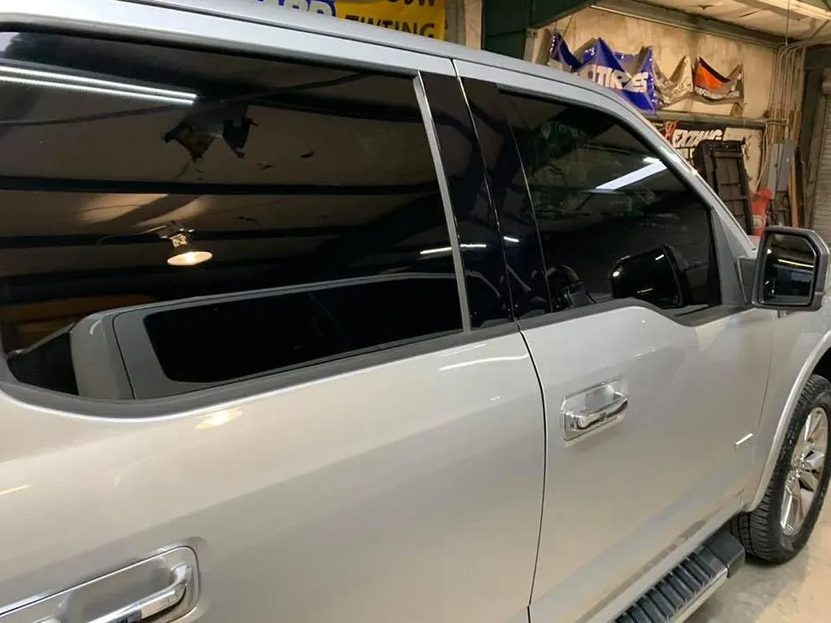 Silver pickup truck with tinted windows, parked inside a building.