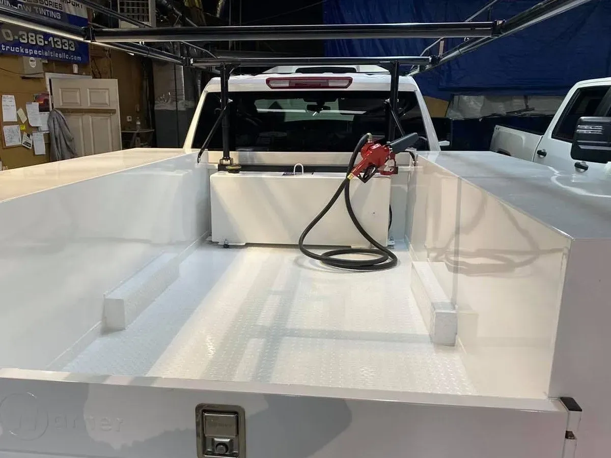 White truck bed with fuel tank and pump.