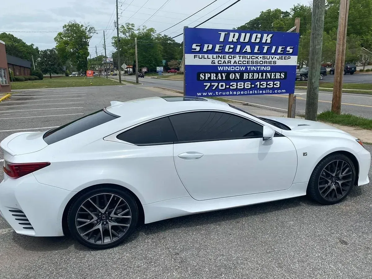 White Lexus RC F coupe parked in front of Truck Specialties sign.