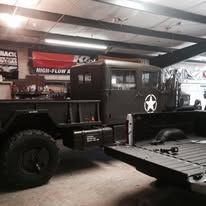 A military truck inside a garage with its back open.