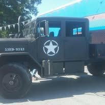 Black military truck with white star emblem.