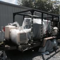 Trailer with covered equipment under a black metal frame.