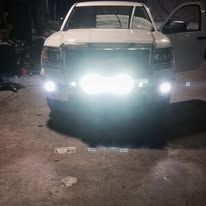 White truck with bright, white light bar in the front, illuminating the darkness.