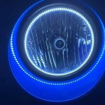 Car headlight with blue and white LED accents, glowing against a dark background.