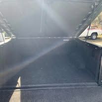 Open truck bed with dark carpet and open tonneau cover.
