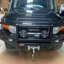 Black Toyota FJ Cruiser, front view, with a heavy-duty bumper.