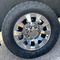 A close-up of a truck wheel with a shiny chrome rim and a black tire.
