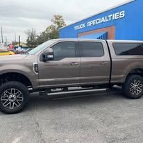 Brown pickup truck parked outside, with a truck cap.