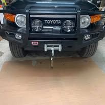 Black Toyota FJ Cruiser with a heavy-duty front bumper and tow hook.