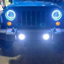 Blue Jeep front with bright blue halo headlights and fog lights on.