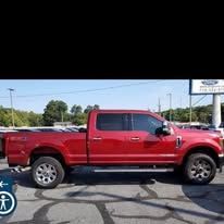 Red Ford pickup truck parked on a street.