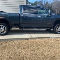 Dark blue pickup truck parked near a light-colored building in an outdoor setting.