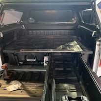 Truck bed interior with storage drawers and a cargo bed organizer.