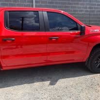 Red truck parked next to a brick wall.