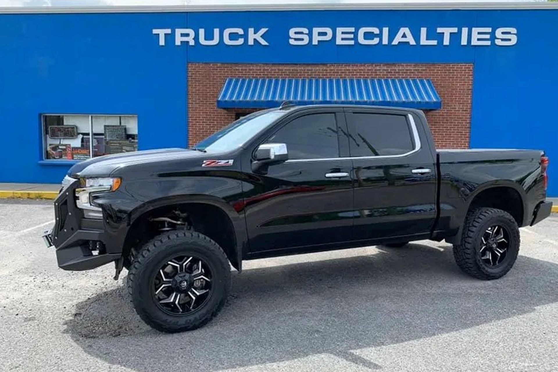 Black lifted Chevrolet Silverado truck parked in front of
