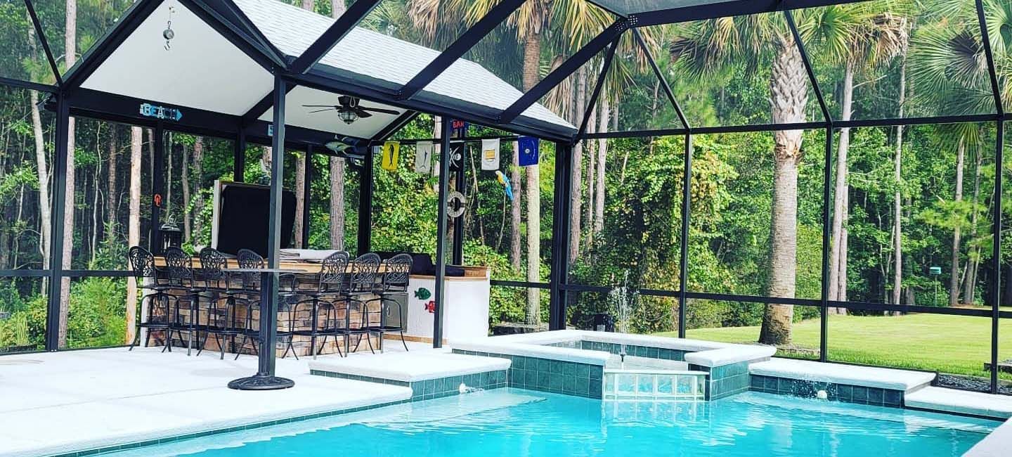 A screened in patio with a swimming pool and a gazebo.