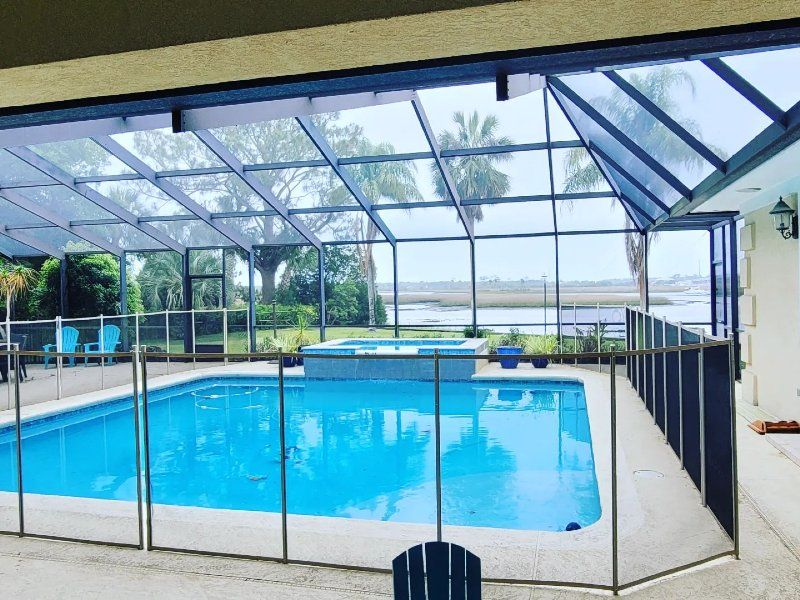 A screened in swimming pool with a fence around it