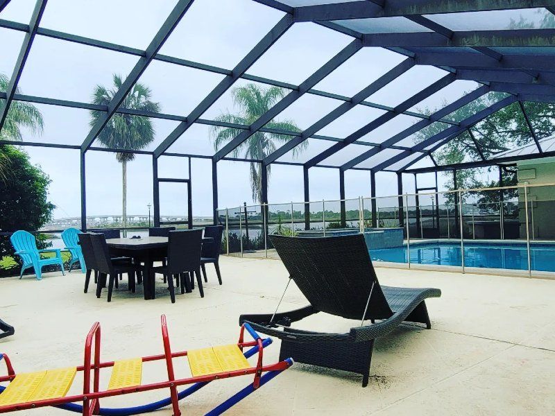 A screened in swimming pool with a table and chairs