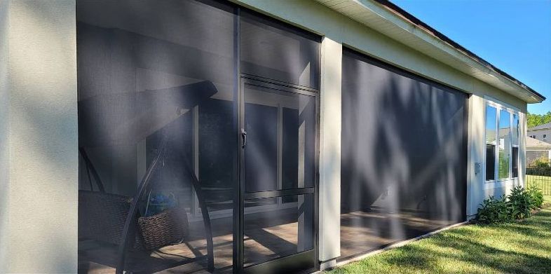 A house with a screened in porch and a patio area.