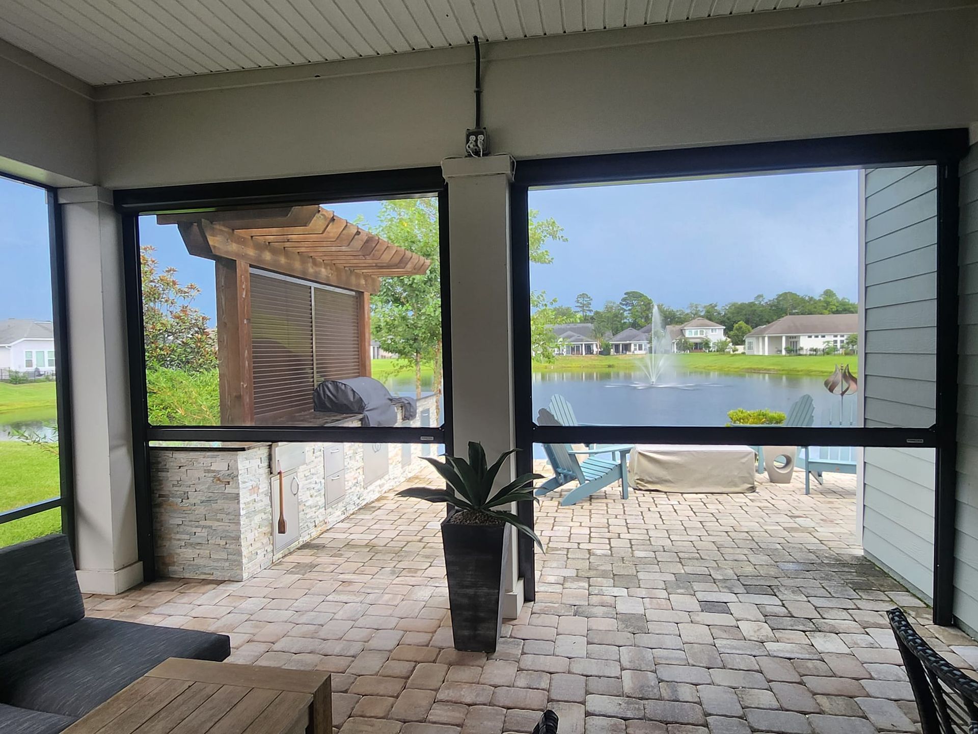 A screened in porch with a view of a lake.