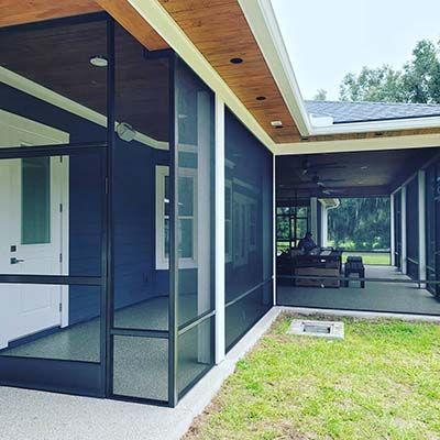 A house with a screened in porch and a large window