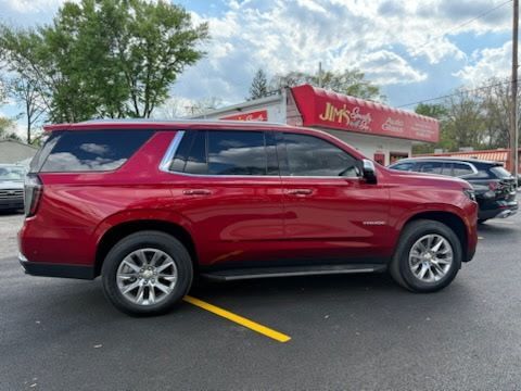 Red SUV parked in a lot in front of a red storefront on a cloudy day.