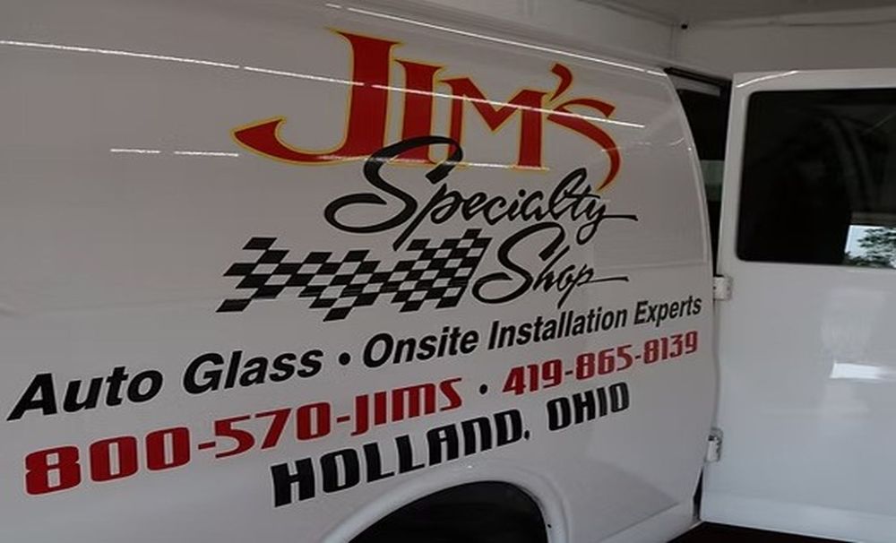 White van with JIM's Specialized Shop auto glass and installation experts logo and contact info.