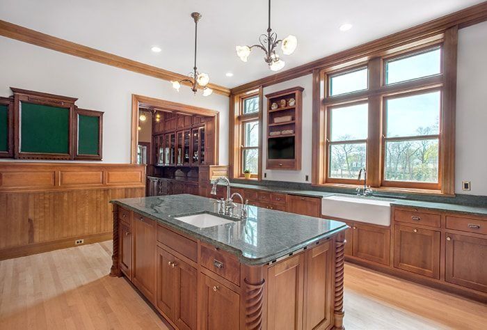 Elegant kitchen with wood cabinets, large island, and windows overlooking a view.