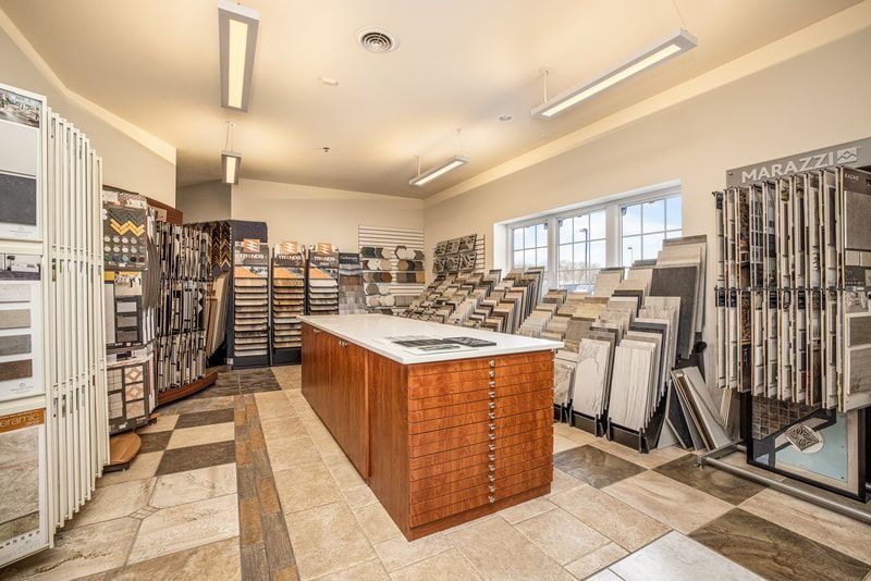 Tile showroom with displays and a central wooden cabinet on a checkered floor.