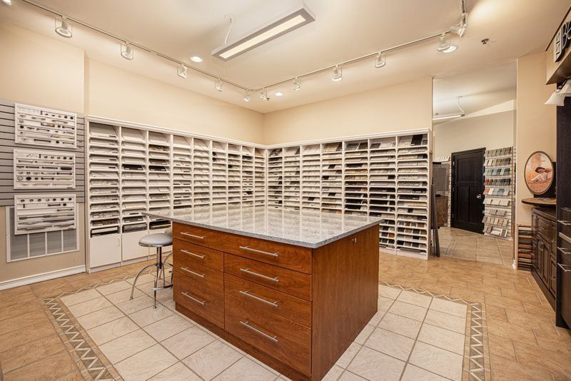 Kitchen design showroom with samples, an island countertop, and a stool.