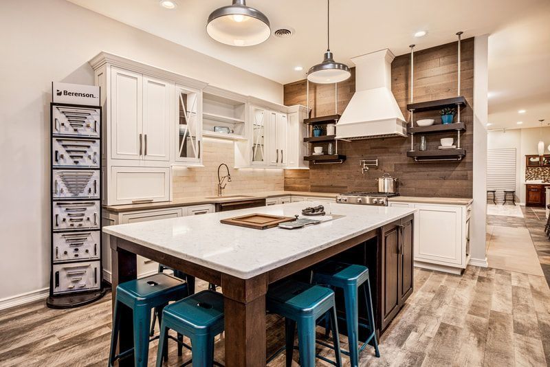 Kitchen with white cabinets, blue stools, and wood accents.